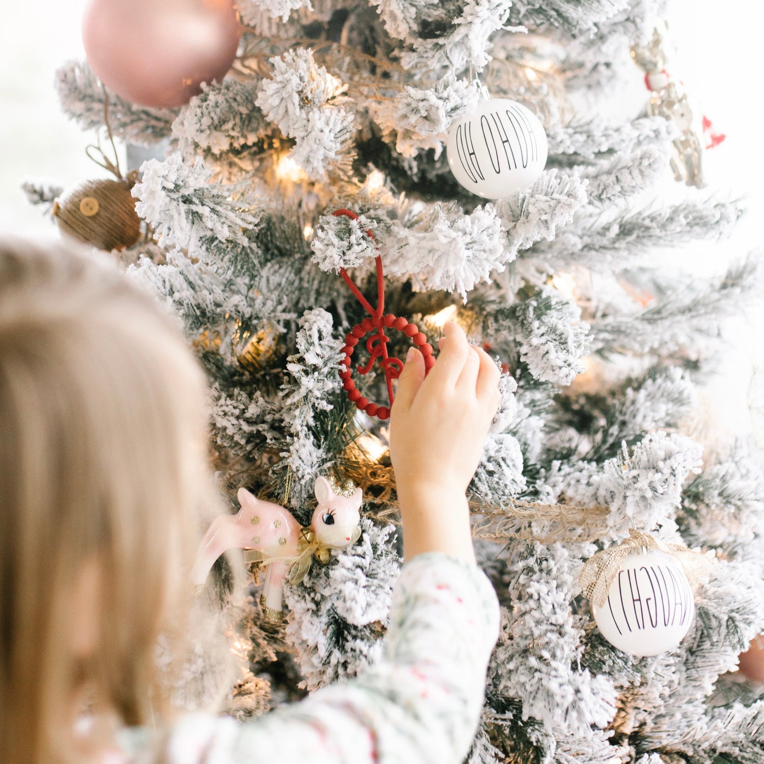 Girl putting ornament on tree