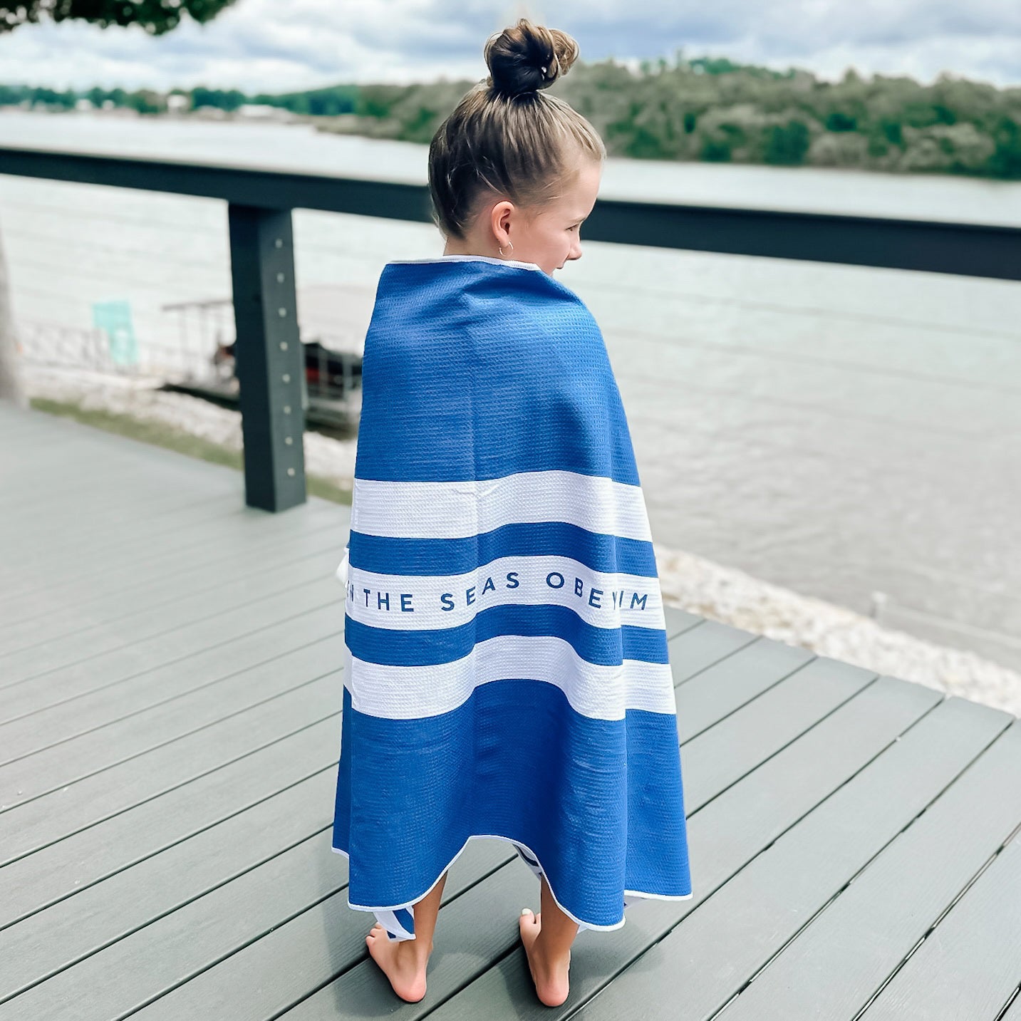 Girl wrapped in towel on deck